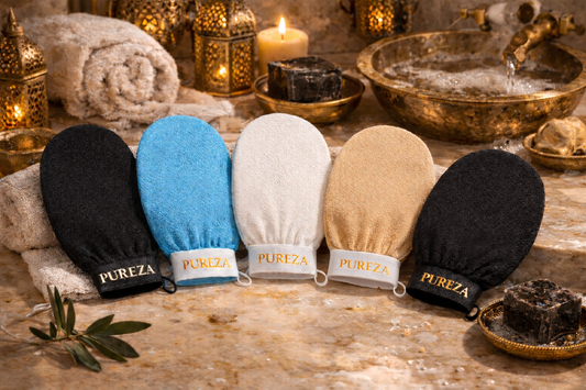 Five Pureza Kessa in black, blue, white, beige, and black on a wooden surface with candles and towels in the background.