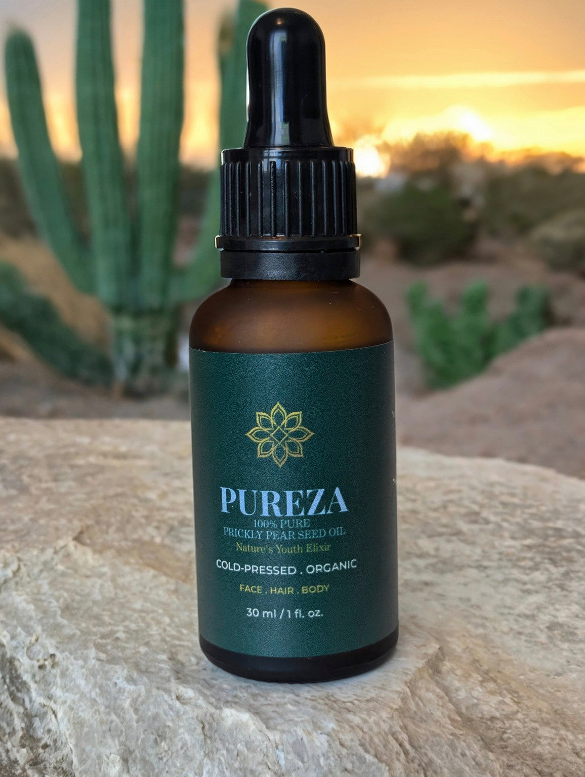 Bottle of Pureza oil with a dropper on a stone surface with cacti in the background