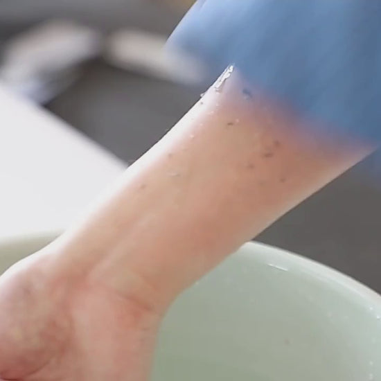 Model using Pureza Kessa glove to exfoliate and remove dead skin